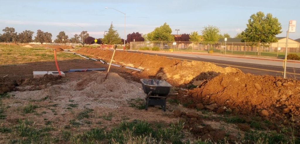 scene with dirt, shovel, wheelbarrow and conduit