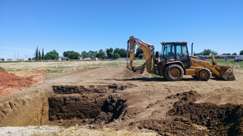 Backhoe by a deep hole