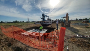 2 men working to set a septic tank