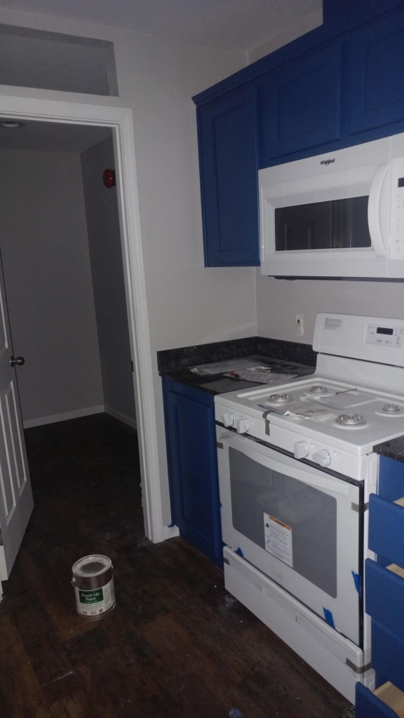 a Kitchen with grey walls and blue cabinets