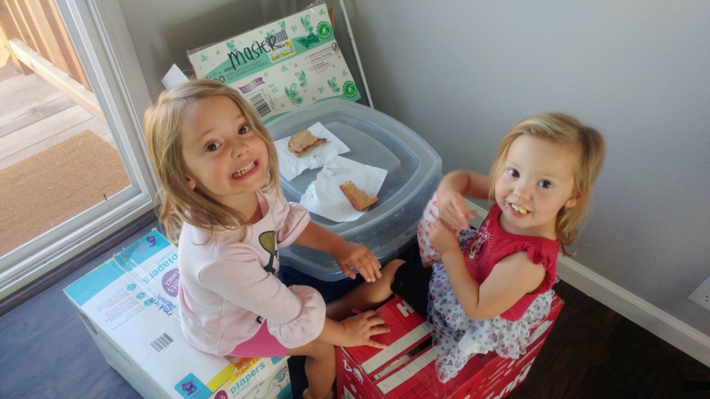 two little girls eating sandwiches