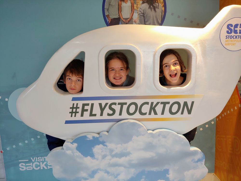 three teenagers with faces in an airplane frame